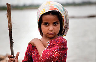 A girl stands in her community’s makeshift camp in the city of Hyderabad, Sindh Province, Pakistan.