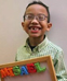 Little boy holds a magnetic board with his name