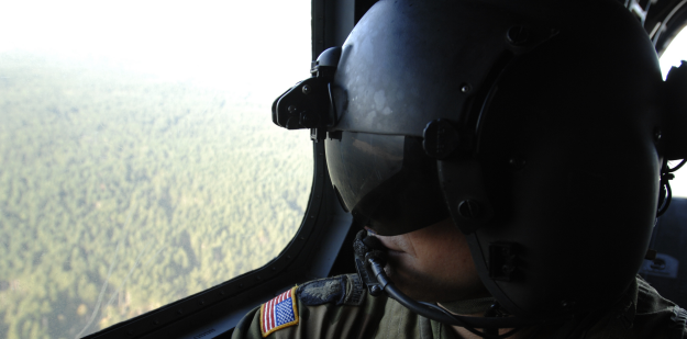 soldier in helicopter with helmet.