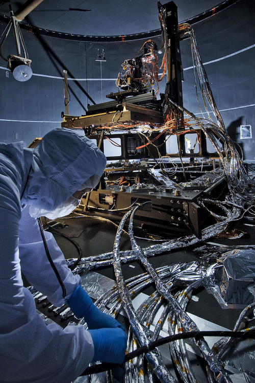 Image description: Erin Wilson, a NASA engineer, adds aluminum tape to electrical cables to protect them from the cold during environmental testing of special optical equipment. These tests will verify the alignment of flight instruments that will fly aboard NASA&#8217;s James Webb Space Telescope.
Photo by Chris Gunn, NASA