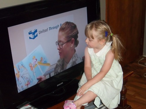 Image description: A young girl listens while her military-duty family member reads aloud a children&#8217;s book on television, prerecorded onto DVD from her place of deployment. April is the Month of the Military Child. Approximately 225,000 military children have a parent who is currently deployed. More than 700,000 children have experienced the deployment of one or more parents since 2001. Learn about resources for military families.
Image courtesy of the U.S. Army.