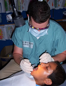 This photo was taken at Delfina Rivas, El Salvador. LT Charles Brucklier, USPHS dental hygienist, placing dental sealants on an El Salvadoran boy.
