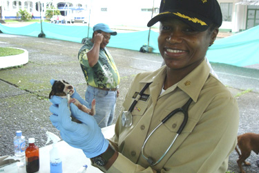 CDR Elvira Hall-Robinson with an 8-day old puppy.