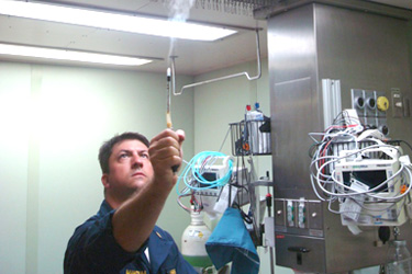 LT Jason Mangum uses a smoke tube to determine airflow direction in an isolation room.