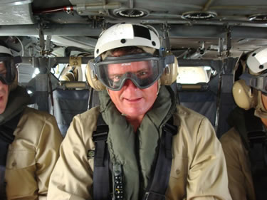 CAPT Craig Shepherd, Officer in Charge, aboard a helicopter.
