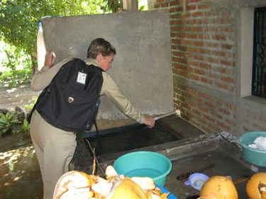 CAPT Cynthia Kunkel, environmental health officer, collecting a water sample at a house near Costa Brava in El Salvador. Many water samples were collected and taken back to ship for analysis ? nearly all tested positive for coliforms and E. coli.