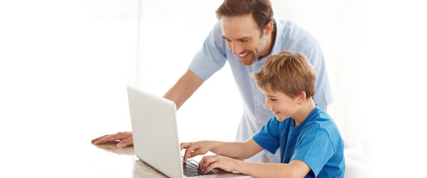 Father teaching his son on a laptop computer
