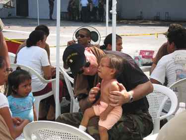 LCDR David Campbell, a nurse practitioner, conducts a medical evaluation on a young patient to help diagnose any existing ailments at the Escuela Santa Isabel in Escuintla in the Republic of Guatemala.