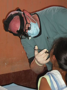 LCDR Philip Wilson, a dentist, performs an oral examination on a young child at the Escuela Santa Isabel in Escuintla, in the Republic of Guatemala.
