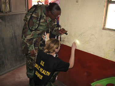 LT Jill Shugart, an Environmental Health Officer,  conducts a surface lead test of paint at Escuela, Guatemala.