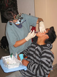 While in Peru, CDR Maria-Paz Smith, a dentist, performs an extensive dental exam on a patient at the Huacho clinic.