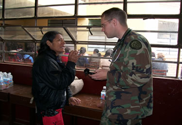While in Peru, LT Timothy McCreary, a physician assistant, discusses health procedures with a patient at the Huacho clinic.