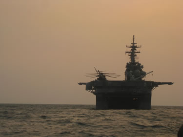 >Photo from the landing craft utility (LCU) of the Commissioned Corps team re-entering onto the USS Boxer at dusk.  The ship uses ballast tanks to drop its stern and then opens its well deck door to allow entry of the LCU, as shown in the photo.  Once the LCU is in the hull of the ship, the door closes and the water is drained so equipment and/or personnel can be removed.