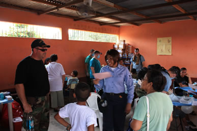 CAPT Dean Coppola, the Officer-in-Charge who is also a dentist, discusses standard dental practices with the dental clinic patients and providers at the Escuela Santa Isabel in Escuintla in the Republic of Guatemala.