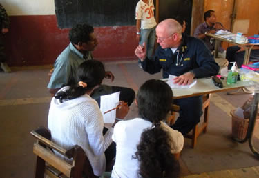 Photo:CAPT Kevin Prohaska, a physician, conducts a patient interview during a Pacific Partnership 2008 medical civic action program at the Nularn 1 School in Dili, Timor Leste. CAPT Prohaska is the USPHS Officer-in-Charge. 