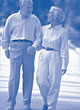 Image of an elderly couple are holding hands and walking.