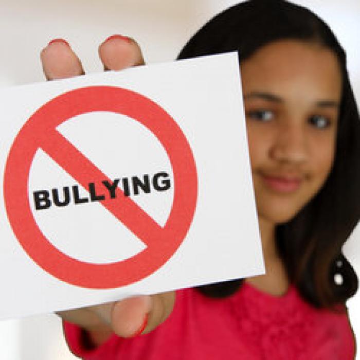 Female child holds anti-bullying sign. 