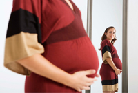 Una mujer embarazada con las manos en su vientre