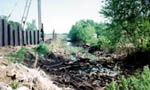 Before Photo: The East Ditch, located at the south end of Bowers Landfill, contained discarded trees and debris
