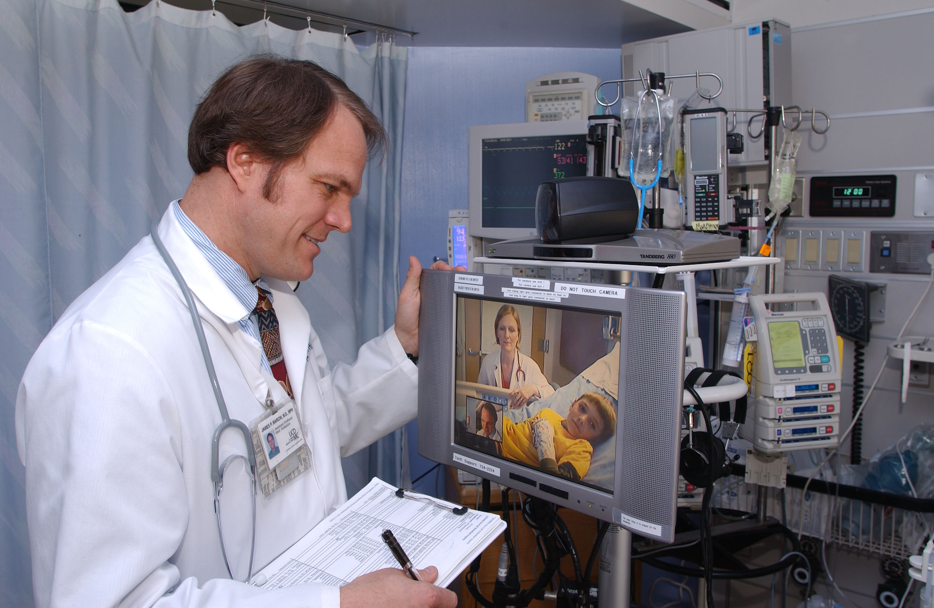 Figure1B - An example of a Teleconsultation. A subspecialist physician consults with another physician, at a distant medical facility, to provide specialty knowledge for treating a child. 