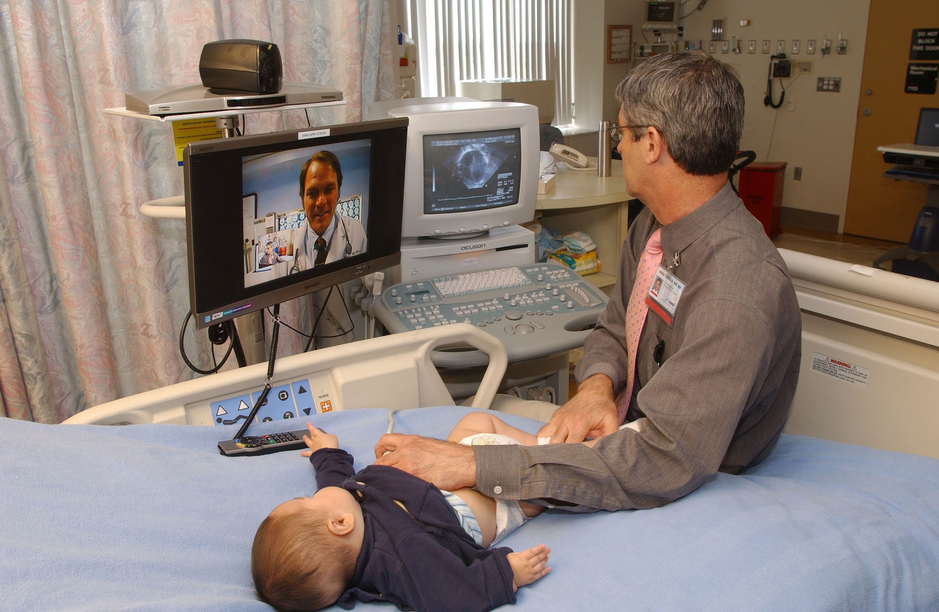 Figure3 - A telecardiology consultation being performed on an infant. A pediatric cardiologist views the real-time performance of an echocardiogram at a distant medical facility. 