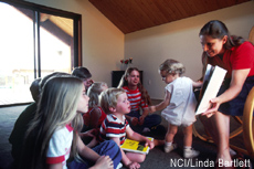 Photograph of a woman reading to children