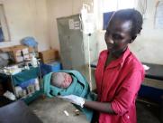 Midwife Rose Jua holds a newborn baby.