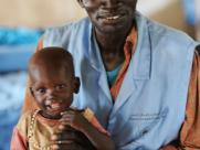 A father holds his young son who was recovering from malaria