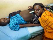 An IRC maternal health worker examines an expectant mother