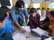 A teacher and boys in an IRC tent classroom in Pakistan