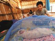 Saw Dah admires his new daughter, born in a Thai refugee camp