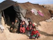 Displaced Afghani family outside their tent