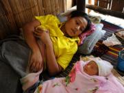 Burmese mother with her newborn daughter at a refugee camp in Thailand 