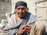An elderly woman sits in her courtyard in rural Pakistan