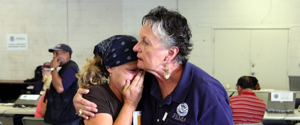 A FEMA worker comforts a disaster victim.