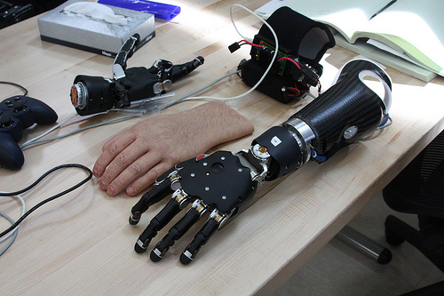 Image description: This brain-controlled modular prosthetic limb (MPL) is controlled by surface electrodes, which pick up electric signals generated by the muscles underneath the skin. The electrodes then convert those patterns into a robotic function.
Walter Reed National Military Medical Center, along with the Johns Hopkins Applied Physics Labratory and the Uniformed Services University of the Health Sciences (USU), developed the limb for military veterans who lost limbs in action.
The arm is the first to be created and has the same dexterity as a natural arm, including independent movement of the fingers.
On January 24, 2012, Air Force Tech Sgt. Joe Delauriers was the first patient to use the MPL. Delauriers was injured in an IED blast in Afghanistan where he lost both his legs and part of his left arm. With the help of the MPL, Delauriers is able to live off base, drive a car and hold his infant son without worrying about infections.
Amputees go through training before being fitted for the MPL. The training records muscle movements and collects data before the MPL is fitted.
Those involved in the program are hopeful about the future of the MPL and creating more limbs for those in the military and hopefully eventually for the public.
Image from the U.S. Navy.