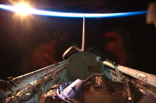 An orbital sunrise brightens this view of space shuttle Discovery