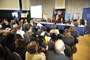 A photo of panel of speakers sitting in front of an audience