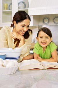 a mother and daughter reading a cook book