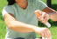 Woman spraying insect repellant on arm.