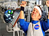 A man lifts weights as a cartoon globe watches