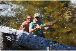 man and son in river with chinook salmon