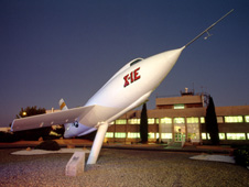 The X-1E in front of NASA Dryden Flight Research Center's main building at night.