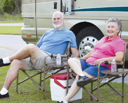 Seniors smiling at a camping site.