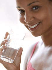 Smiling woman holding a glass of water.