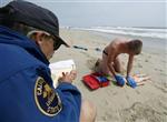 California lifeguard trainee Robert Phelps it tested by instructor Ed Vodrazka (L) as he rescues a child prop from the ocean and performs CPR in Huntington Beach, California June 2, 2007. REUTERS/Mike Blake