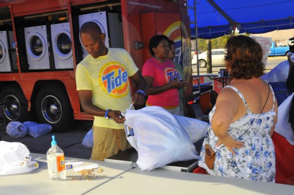 LaPlace, La., Sep. 4, 2012 -- Roger Bostic, left, and Raynell Parker McNeil bag laundry for washing, drying, and folding for a family affected by Hurricane Isaac. Hundreds in LaPlace, La affected by Hurricane Isaac have taken advantage of the service provided by Tide at no charge.
