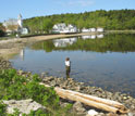 Photo of Lyndie Hice checking water temperature and salinity along the coast of Maine.
