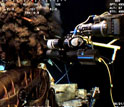 Photo of the manipulator arm of a robotic vehicle, upper right, moving sampler toward oil and gas.