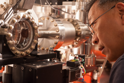 SLAC staff scientist Yiping Feng examines a chamber at LCLS' Front End Enclosure, where a thin crystal spectrometer is installed to measure the shot-by-shot characteristics of X-ray laser pulses. | SLAC National Accelerator Photo by Matt Beardsley
